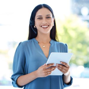 Portrait of a young call centre agent working on a digital tablet in an office